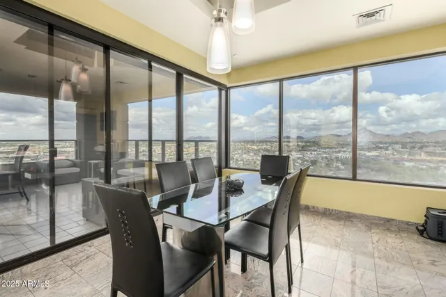 a dining room with furniture water view and a floor to ceiling window