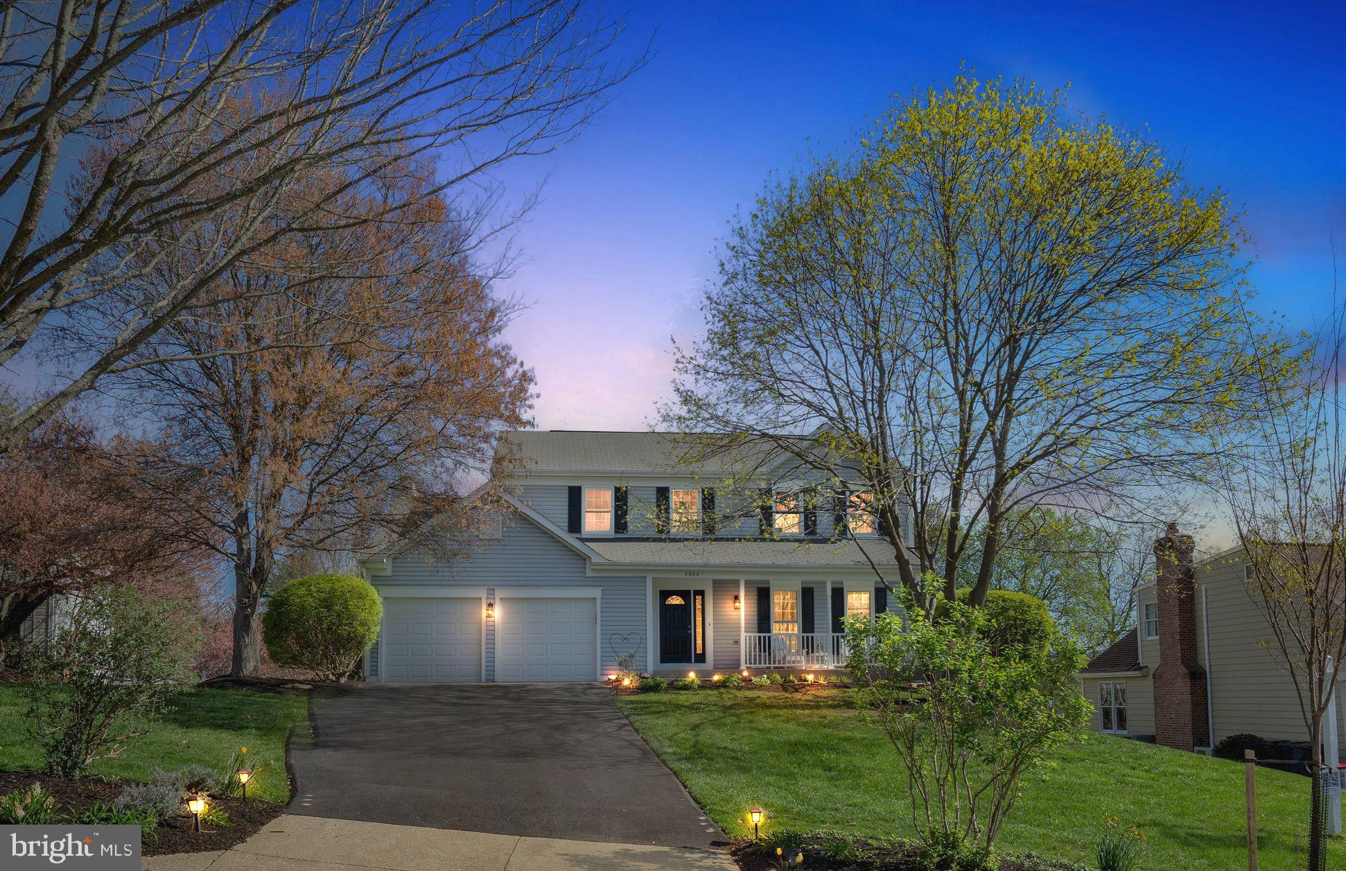 a front view of a house with a garden and plants
