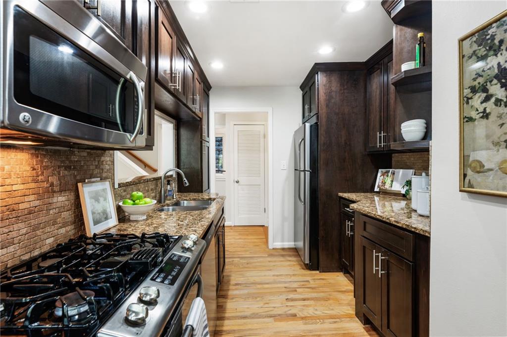 4010 Roswell Road Northeast, Unit 7 Atlanta, GA 30342 - Photo 16 of 36 a kitchen with stainless steel appliances granite countertop a stove and a refrigerator