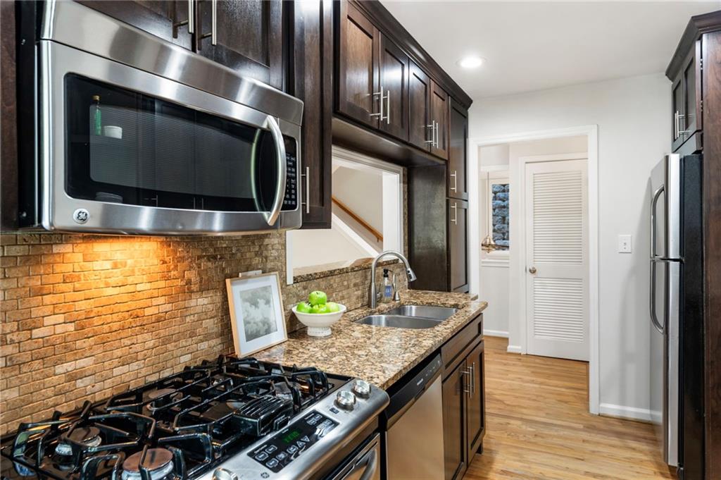 4010 Roswell Road Northeast, Unit 7 Atlanta, GA 30342 - Photo 17 of 36 a kitchen with stainless steel appliances granite countertop a stove and a wooden cabinets
