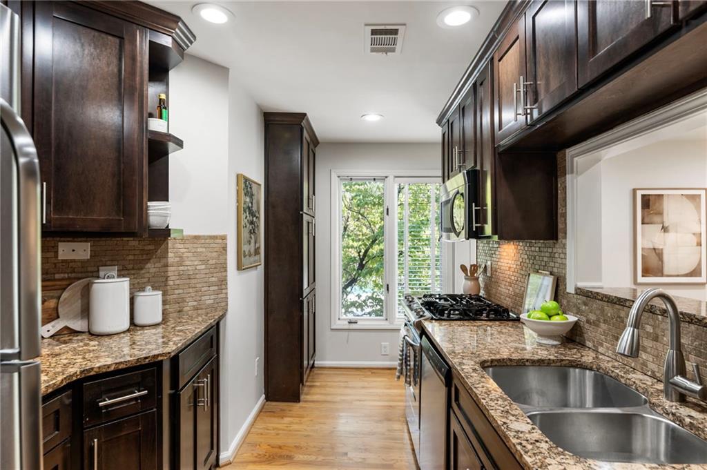 4010 Roswell Road Northeast, Unit 7 Atlanta, GA 30342 - Photo 18 of 36 a kitchen with stainless steel appliances granite countertop a sink a stove and a refrigerator