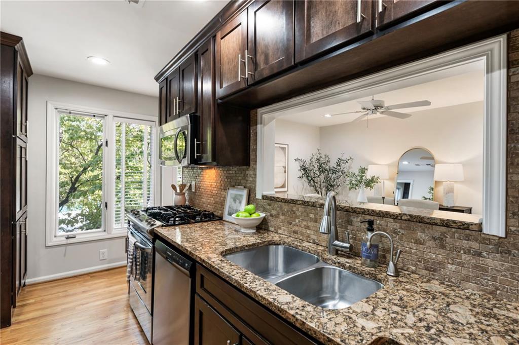 4010 Roswell Road Northeast, Unit 7 Atlanta, GA 30342 - Photo 19 of 36 a kitchen with granite countertop stainless steel appliances a sink window and cabinets