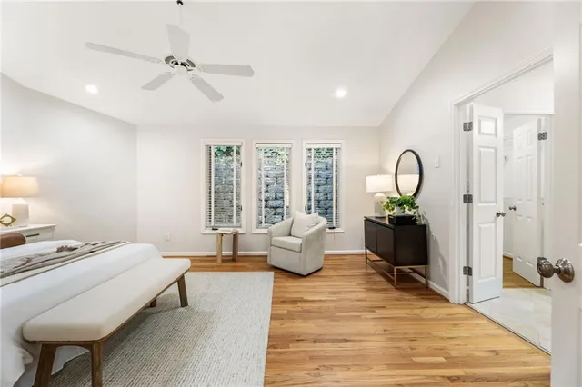 an empty room with wooden floor and a ceiling fan
