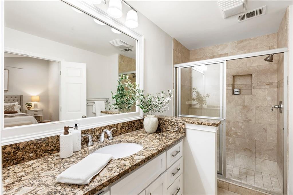 4010 Roswell Road Northeast, Unit 7 Atlanta, GA 30342 - Photo 27 of 36 a bathroom with a granite countertop sink a mirror and a shower