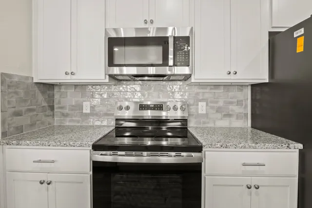 a kitchen with granite countertop stainless steel appliances sink and window