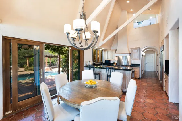 a view of a dining room with furniture a chandelier and wooden floor