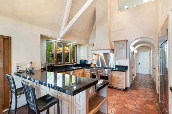 a dining hall with stainless steel appliances kitchen island granite countertop a dining table and chairs