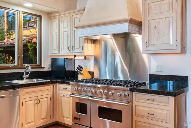 a kitchen with granite countertop a white cabinets and a stove