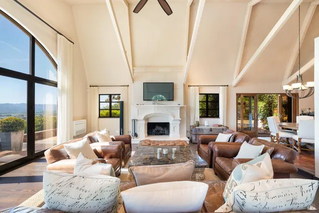 a living room with furniture fireplace and a large window