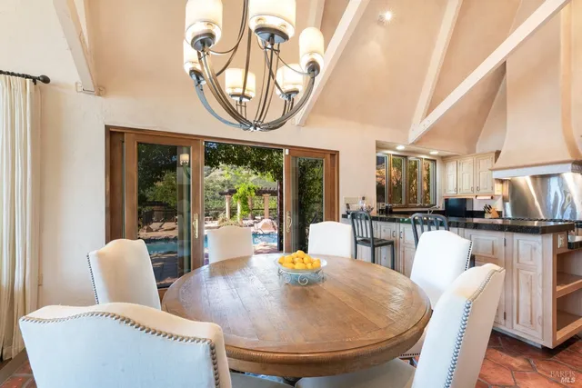 a dining room with furniture a kitchen view and a chandelier