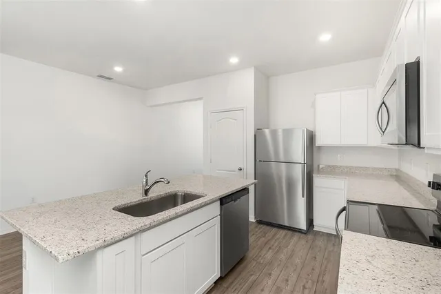 a kitchen with a sink a refrigerator and a stove top oven
