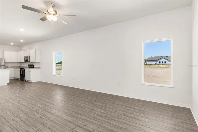 a view of a kitchen with wooden floor and a kitchen space with a sink