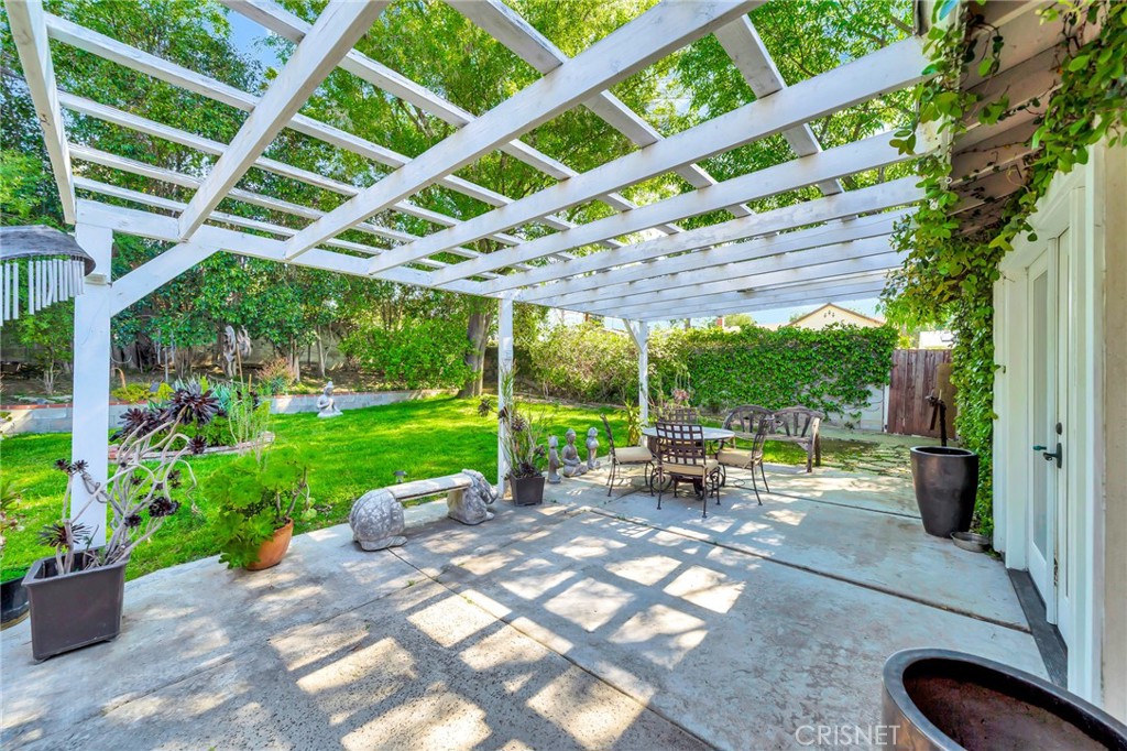 24201 St Edens Circle West Hills, CA 91307 - Photo 21 of 31 a view of a patio with table and chairs potted plants and floor to ceiling window