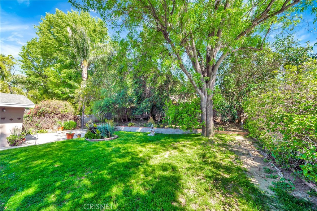 24201 St Edens Circle West Hills, CA 91307 - Photo 24 of 31 a view of backyard with table and chairs and large trees