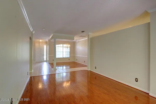 a view of empty room with wooden floor