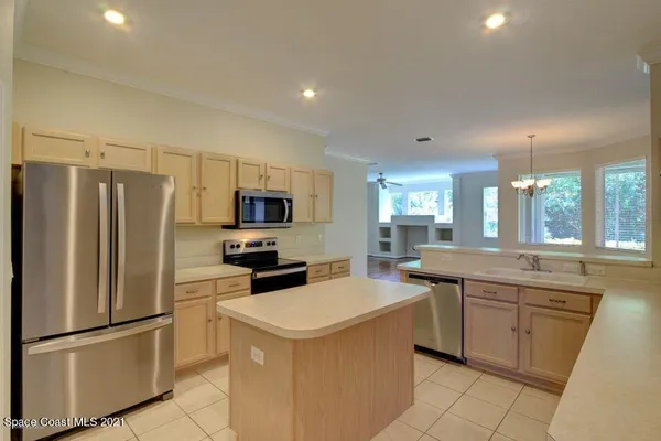 a kitchen with a sink a refrigerator and white cabinets