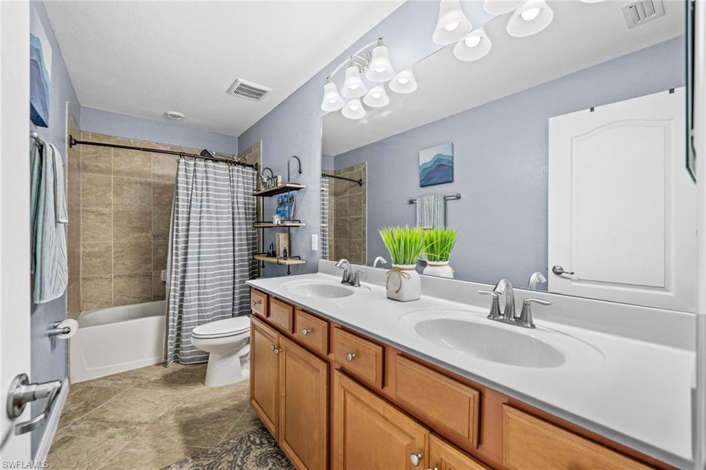 4754 Abaca Circle Naples, FL 34119 - Photo 27 of 46 a bathroom with a sink double vanity and shower
