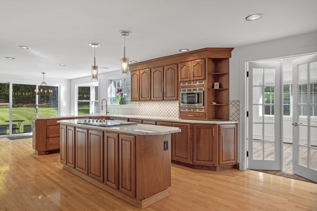 21 Porter Road Boxford, MA 01921 - Photo 9 of 42 a kitchen with stainless steel appliances granite countertop a stove a sink dishwasher and a refrigerator with wooden floor