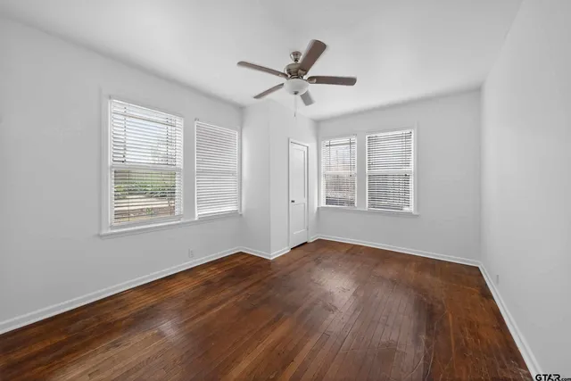 a bathroom with a granite countertop sink vanity mirror and toilet