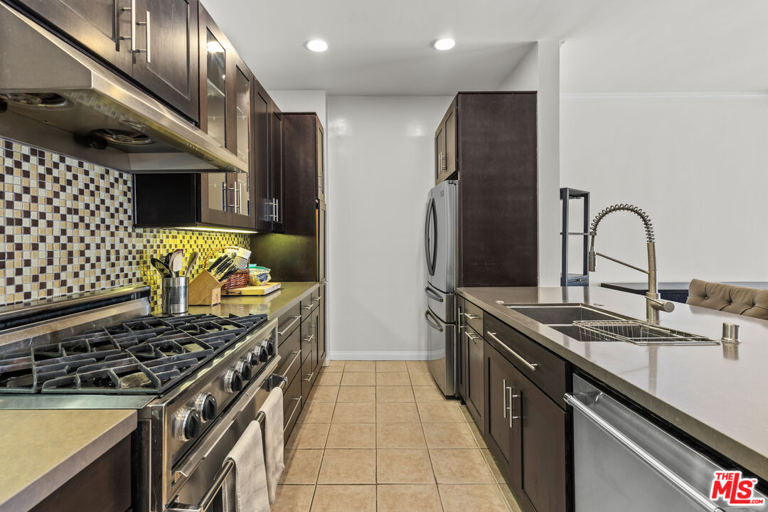 1260 South Beverly Glen Boulevard, Unit 305 Los Angeles, CA 90024 - Photo 11 of 28 a kitchen with stainless steel appliances granite countertop a stove and a sink