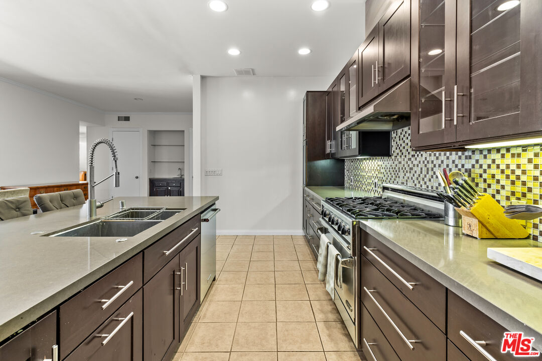 1260 South Beverly Glen Boulevard, Unit 305 Los Angeles, CA 90024 - Photo 12 of 28 a kitchen with stainless steel appliances granite countertop a sink stove and cabinets