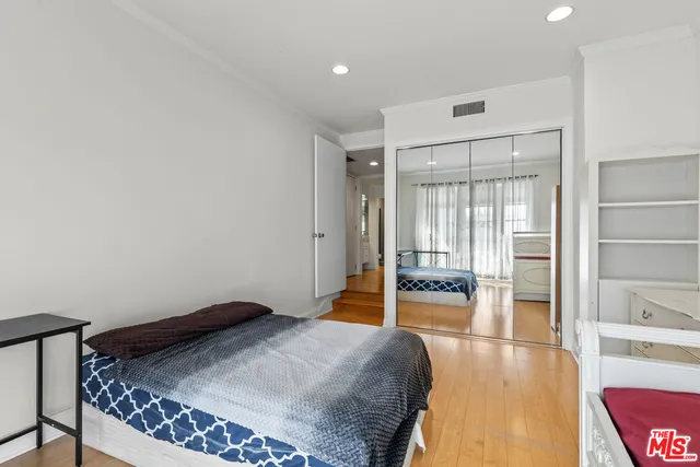 a bedroom with a bed and wooden floor