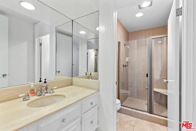 a bathroom with a shower sink vanity granite and mirror