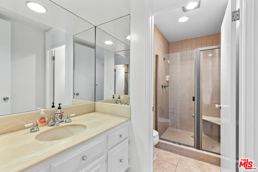 1260 South Beverly Glen Boulevard, Unit 305 Los Angeles, CA 90024 - Photo 21 of 28 a bathroom with a shower sink vanity granite and mirror