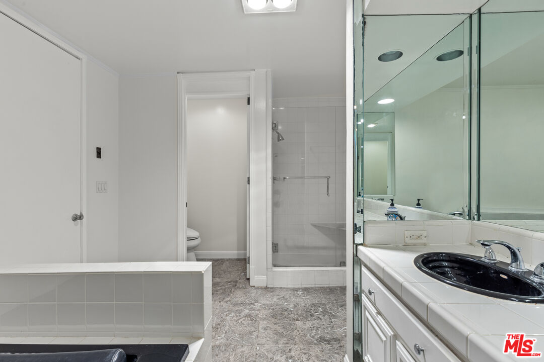 1260 South Beverly Glen Boulevard, Unit 305 Los Angeles, CA 90024 - Photo 27 of 28 a bathroom with a sink a toilet and shower
