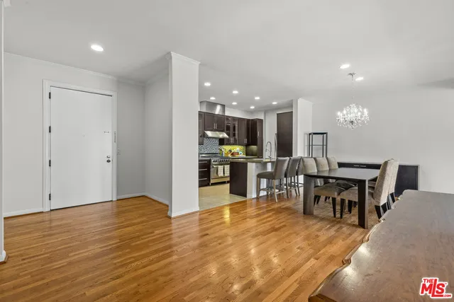 a view of a dining hall with kitchen island stainless steel appliances refrigerator and a dining table chair