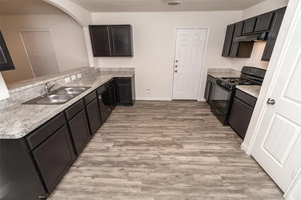 a kitchen with stainless steel appliances granite countertop a stove top oven a sink and a granite counter tops