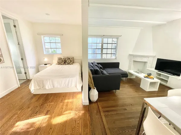 a bedroom with a bed a couch and a window