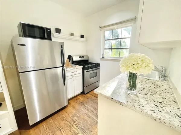 a kitchen with stainless steel appliances granite countertop a refrigerator sink stove and microwave