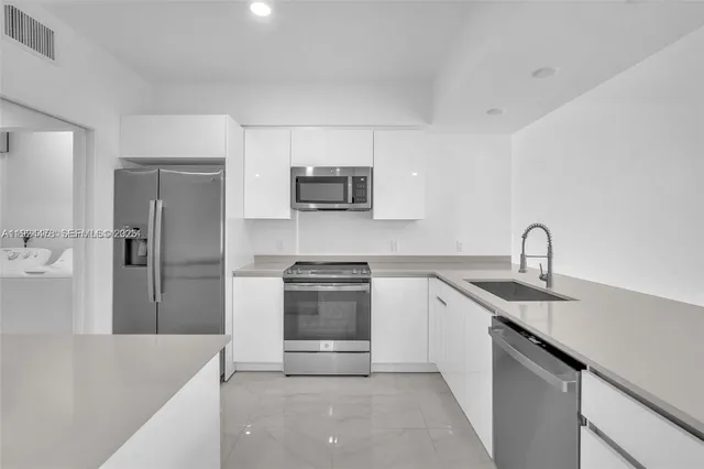a kitchen with stainless steel appliances granite countertop a sink stove and refrigerator