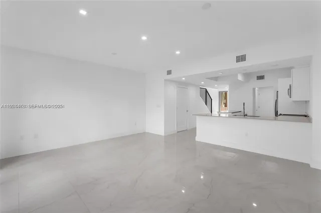 a view of kitchen with refrigerator and a sink