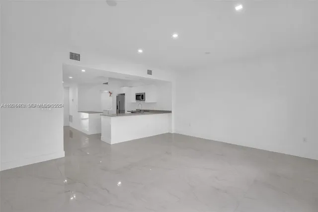 a view of kitchen with kitchen island white cabinets and refrigerator