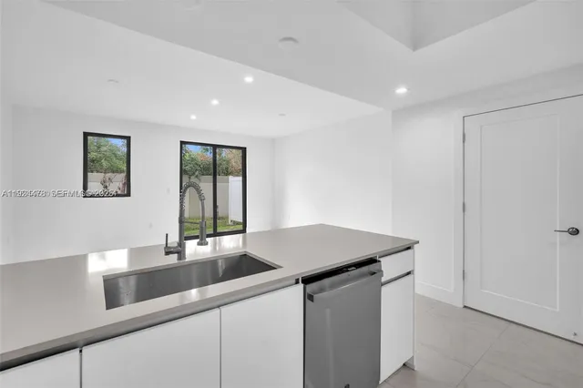 a kitchen with a sink dishwasher and a refrigerator