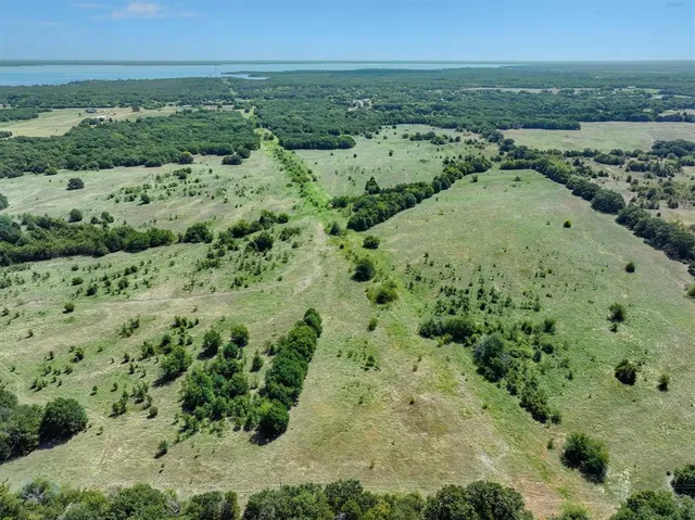 an aerial view of residential houses with outdoor space and trees