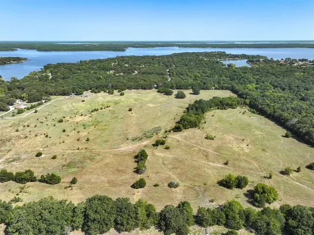 an aerial view of residential houses with outdoor space and trees