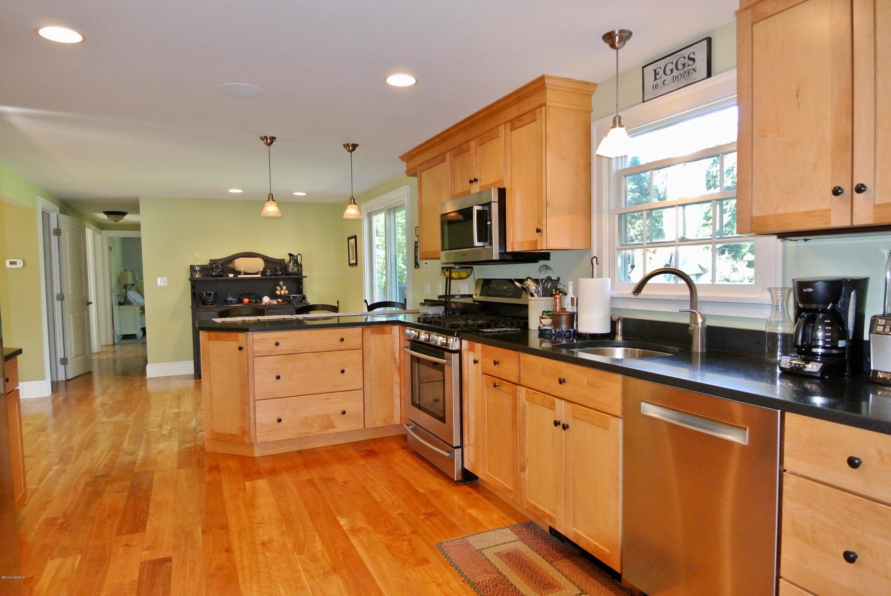 3136 State Road Richmond, MA 01254 - Photo 19 of 29 a kitchen with stainless steel appliances a sink a stove and a wooden cabinets