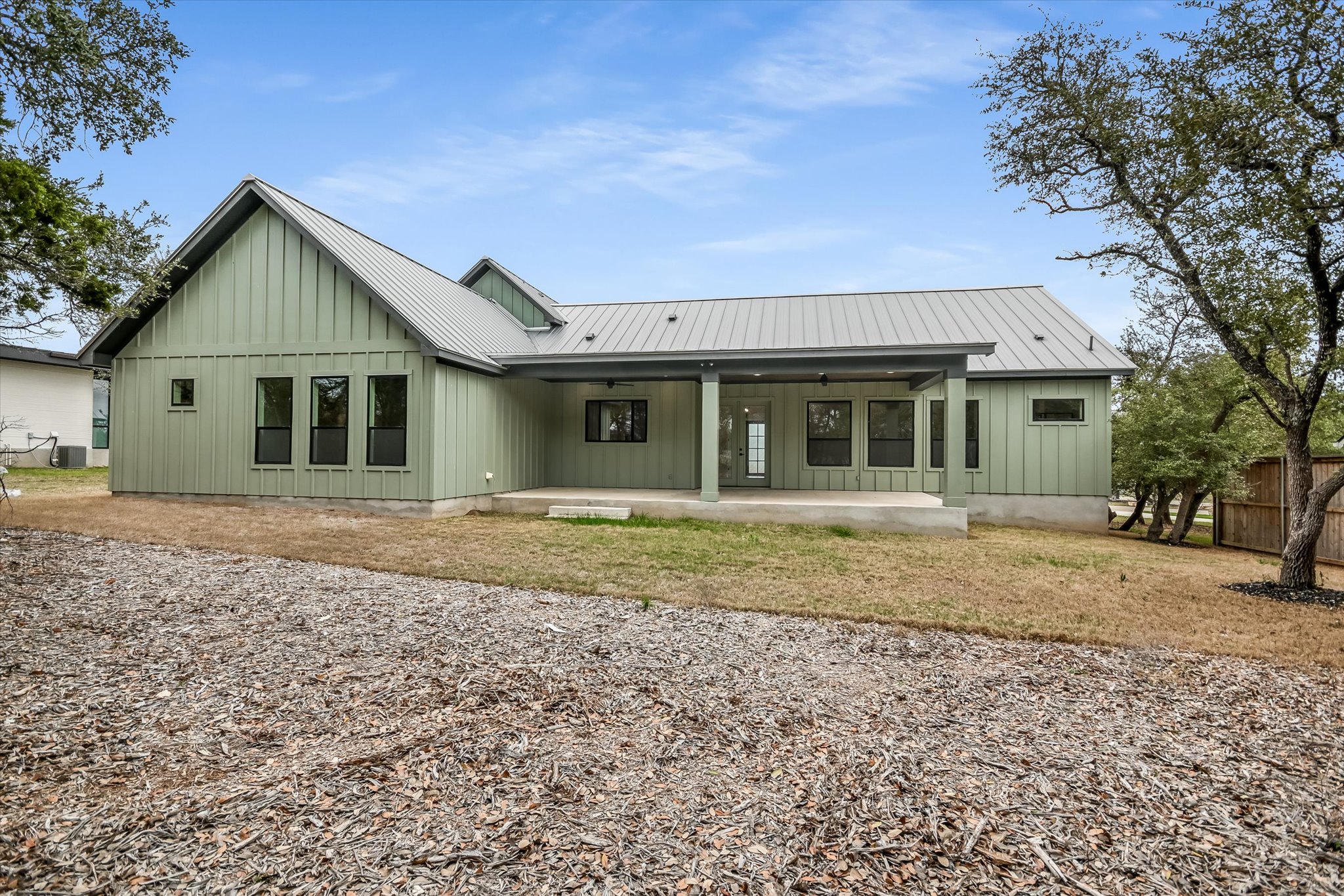 32 Peace Pipe Wimberley, TX 78676 - Photo 19 of 20 Back of property featuring board and batten siding, a patio area, and a metal roof