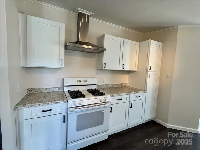 a kitchen with stainless steel appliances granite countertop a sink a stove and cabinets