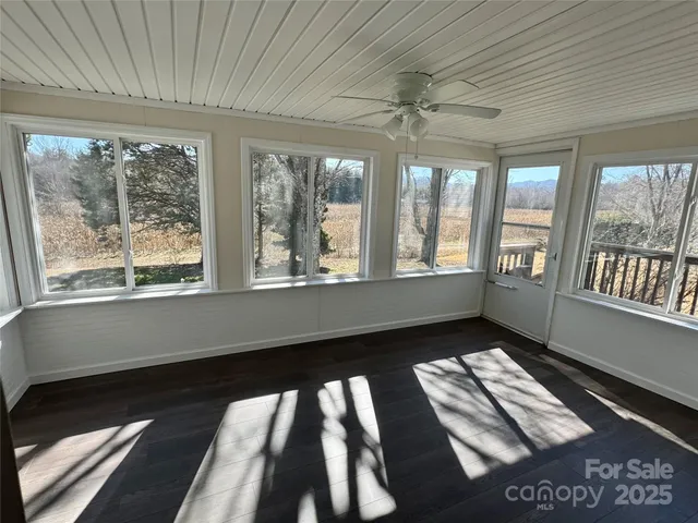 a room with large windows and furniture