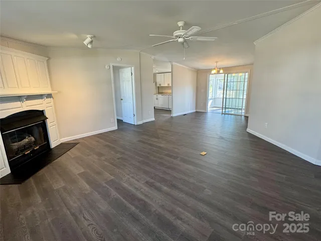 a view of an empty room with a fireplace and a window