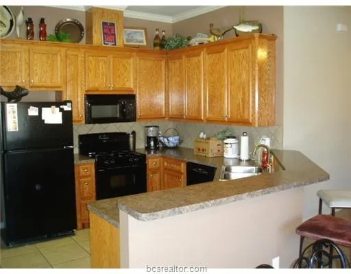 a kitchen with stainless steel appliances granite countertop a refrigerator a stove top oven and a sink