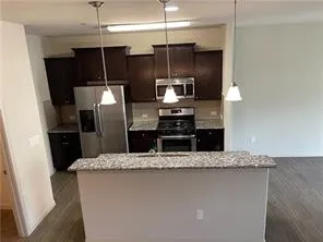 a kitchen with kitchen island a counter top a sink and stainless steel appliances