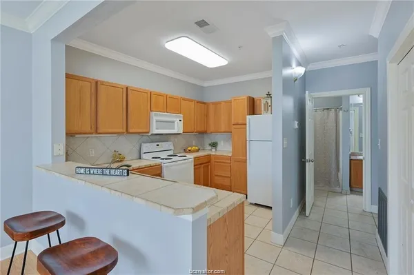 a kitchen with a refrigerator a sink dishwasher and a stove with wooden cabinets