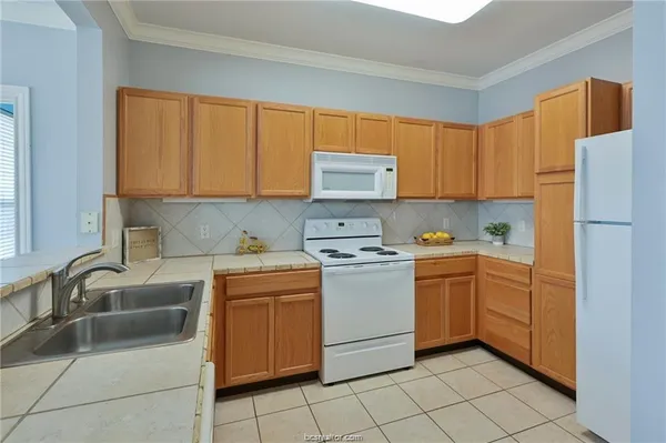 a kitchen with a refrigerator sink and cabinets