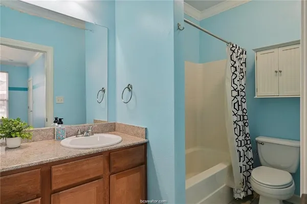 a bathroom with a granite countertop sink toilet and shower