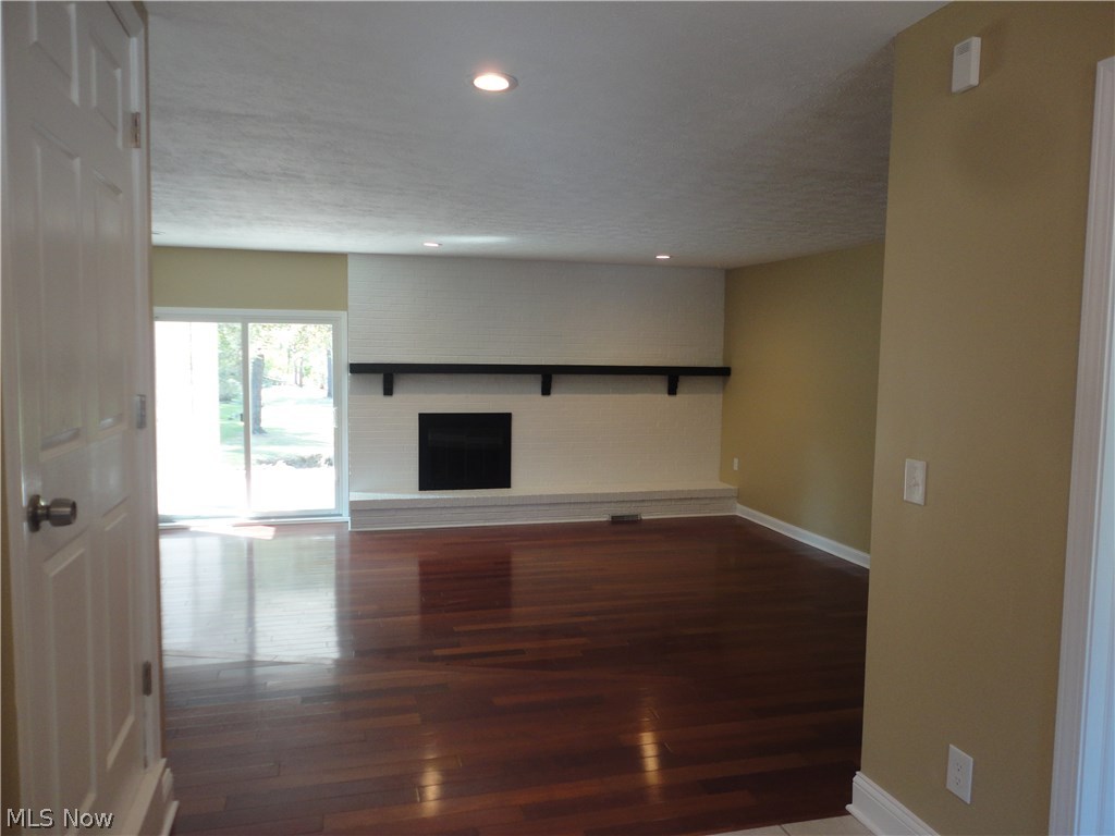 19646 Prospect Road Strongsville, OH 44149 - Photo 6 of 32 Viewing the step down living room with wood burning fireplace. glass doors lead to a covered patio with additional access off master bedroom.